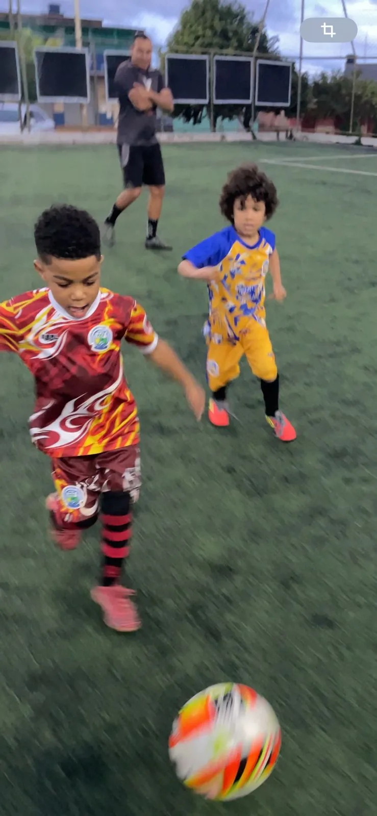 Pequenos atletas disputando a bola em jogo da categoria de base